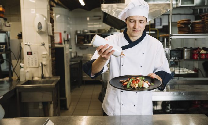 cook-pouring-sauce-big-plate-with-salad